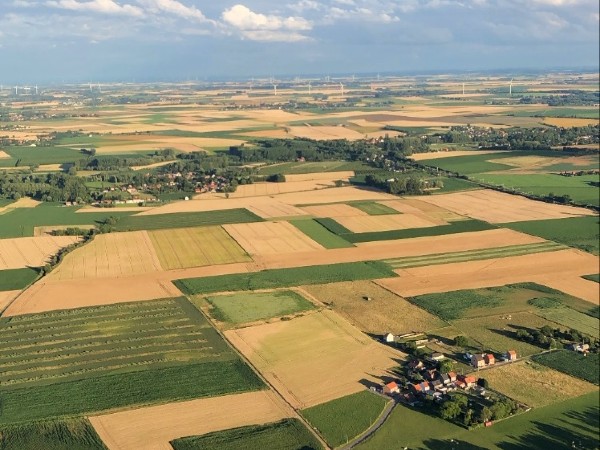 Glooiende landschap regio Tienen tijdens de ballonvlucht uitgevoerd door Filva Ballonvaarten.